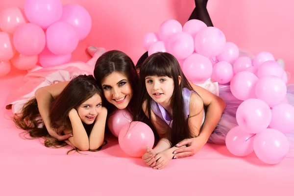 Jovens meninas felizes com a mãe com balões rosa — Fotografia de Stock