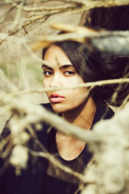 Sevimli kız yapraksız ağaç dallarında gizleme