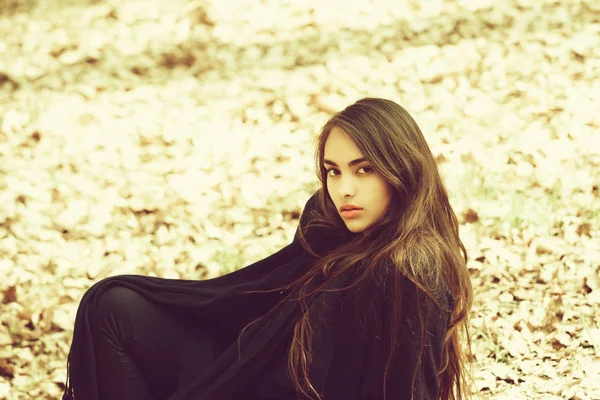 Flicka med långa, brunett hår som sitter på marken — Stockfoto