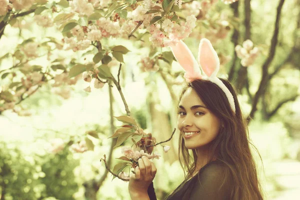 Vrouw die lacht op boom met bloeiende sakura bloemen — Stockfoto