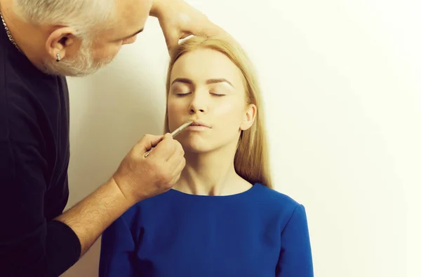 Hombre aplicando polvo en la cara de chica con cepillo de maquillaje — Foto de Stock