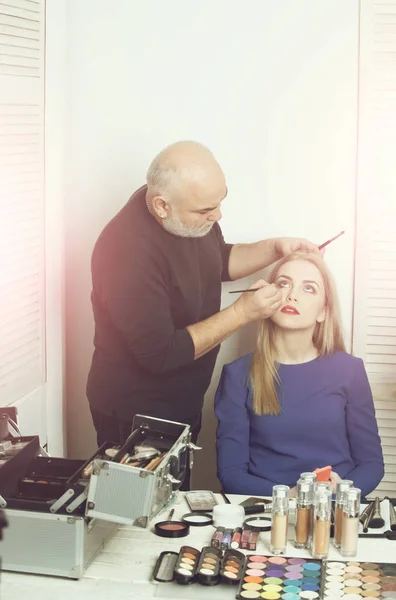 Visagiste aplicando maquiagem nos olhos no rosto da menina — Fotografia de Stock