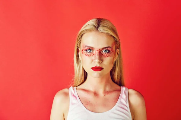 Mooie blonde vrouw met creatieve modieus make-up op rode rug — Stockfoto