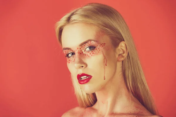 Meisje of vrouw met creatieve modieus make-up op rode achtergrond — Stockfoto