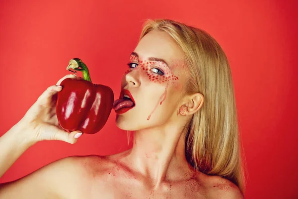 Meisje met creatieve modieuze make-up likken paprika — Stockfoto