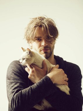 adam holding şirin kedi kollarında