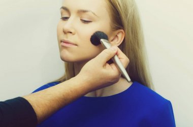 Toz yüzünde makyaj fırçası ile el kızı