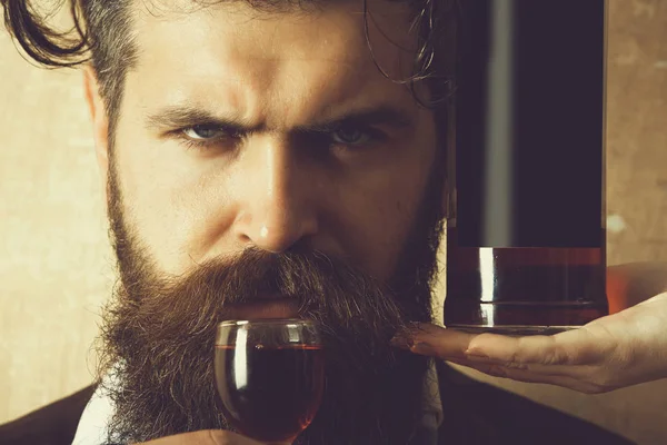 Man drinking wine from glass with bottle on female hand