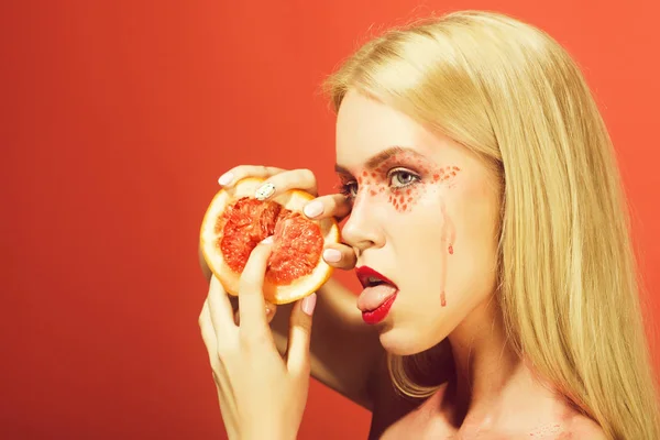 Hübsches Mädchen mit stilvollem Make-up lecken Grapefruit, Vitamin — Stockfoto