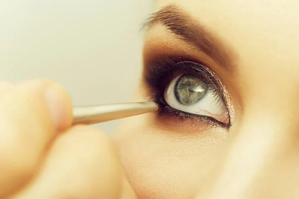 Frauenauge bekommt Make-up mit schwarzem Schatten und Pinsel — Stockfoto