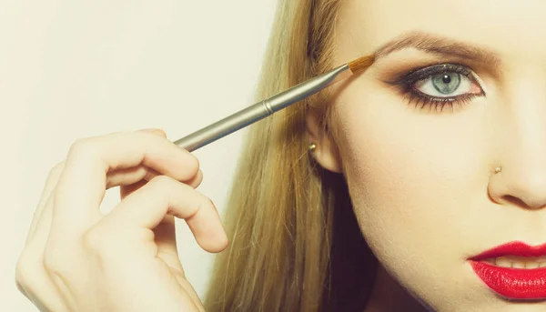Mulher meia face desenho sobrancelha com escova de maquiagem — Fotografia de Stock