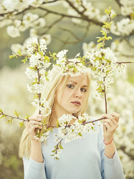 Mooie jonge vrouw genieten van geur in een bloeiende lente garde — Stockfoto