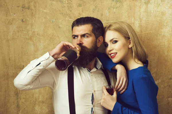 Mann trinkt Wein aus Flasche und Mädchen lächelt mit Glas — Stockfoto