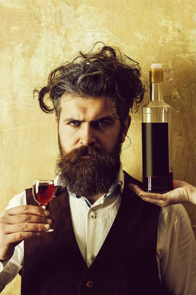 Man posing with wine glass and bottle on female hand