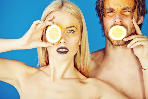 young couple of woman and man with makeup hold lemon