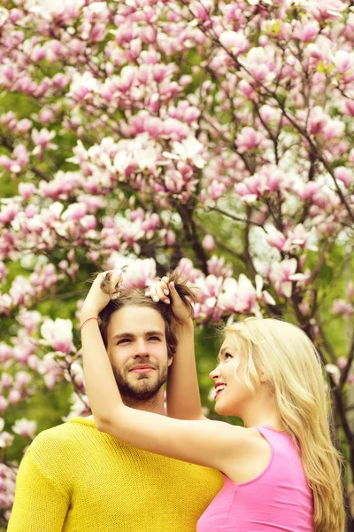 Vänner eller älskande nära magnolia blomma, par i kärlek — Stockfoto