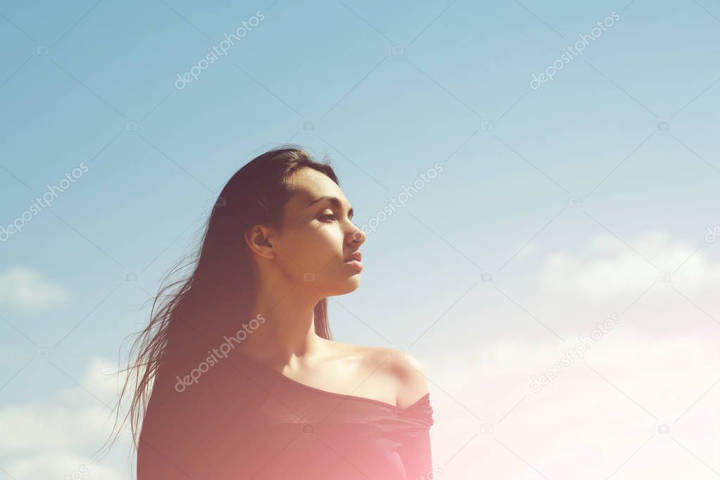 woman posing in black top on blue sky