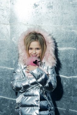 Küçük çocuk gülümseme ile uzun sarı saçlar, saç, güzellik. Kız kış ceket kürk başlık, moda ile. Çocuk moda trendi ve stil. Bebek güzellik, saç ve göz. Çocukluk ve gençlik cilt bakım kavramı