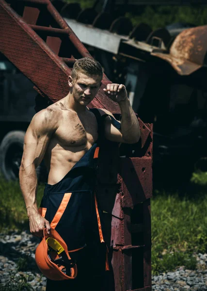 Sexy handyman concept. Muscular builder holds hard hat — Stock Photo, Image