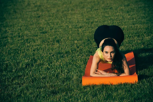 Woman doing plank exercise outdoor on green grass — Stock Photo, Image