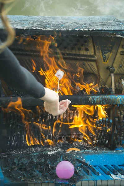 Το κορίτσι είναι το μαγείρεμα marshmallows στην καύση πιάνο στην πυρκαγιά — Φωτογραφία Αρχείου