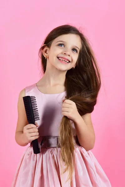 Porträt eines lächelnden kleinen Mädchens, das sich die Haare bürstet — Stockfoto