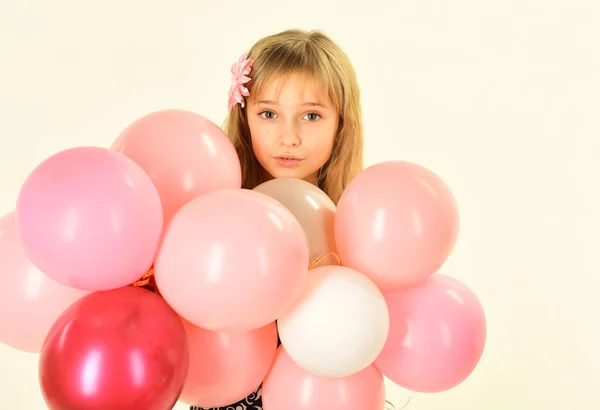 Schönheit und Mode, kraftvolle Pastelltöne. kleines Mädchen mit Frisur halten Luftballons. kleines Mädchen mit Party-Luftballons, Feier. Kind mit Luftballons zum Geburtstag. Geburtstag, Glück, Kindheit, Blick. — Stockfoto