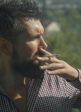 adam Sigara İçilmeyen. Genç hipster sakal ve bıyık üzerinde ciddi bir yüz duman sigara açık sakallı. sağlıksız yaşam tarzı ve bağımlılığı ile adamın kötü alışkanlık. Kuaför ve berber dükkanı