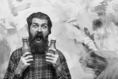 iki plastik şişe tutan şaşırmış sakallı adam