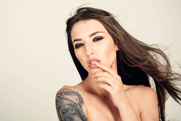 Tattoo, art, design, painting, draw, culture. Sensual woman with tattooed shoulder, painting. Woman with long brunette hair, hairstyle, beauty. Beauty, fashion, look, makeup. Skin care, body art.