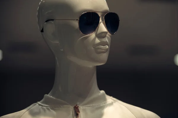 Концепция покупок и одежды. Сияющая модная роскошная кукла. Белая пластиковая голова манекена с белым воротником пиджака. Манекен в солнечных очках на темном, сером фоне . — стоковое фото