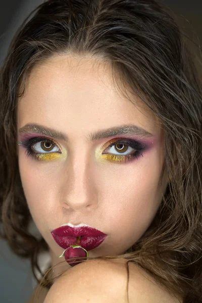 Mulher com rosa vermelha na boca, dia das mulheres. Menina de beleza com aparência glamour, maquiagem e flor em lábios roxos. Modelo de moda com cabelos longos morena, penteado. Dia das mulheres, 8 de março, conceito de primavera — Fotografia de Stock