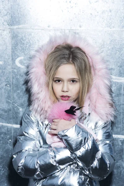 Kid fashion trend and style. Girl in winter coat with fur hood, fashion. Little child with long blond hair, hairstyle and beauty. Baby beauty, hair and look. Childhood and youth skincare concept