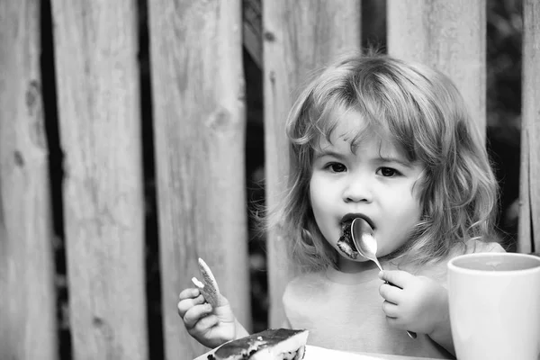 小男孩吃馅饼木栅栏附近 — 图库照片