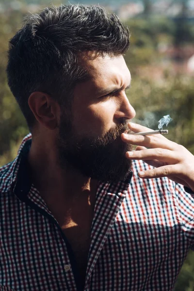 年轻的胡子时髦的胡子和胡子严重面对吸烟户外香烟。抽烟的人。不健康的生活方式和成瘾的人的坏习惯。理发师和理发店 — 图库照片
