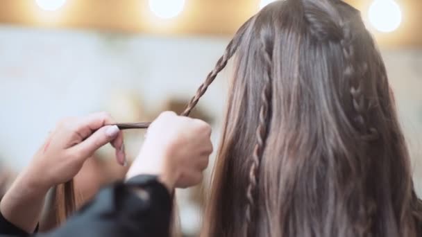 髪型を作るマスター ビューティー サロンの女の子 プロの美容師がお団子と美しい健康的な髪のカールの髪型をしています 白人女性のピグテール ヘアスタイル — ストック動画