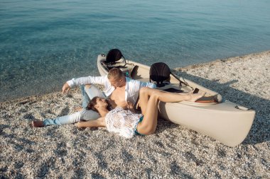 Güneşli yaz gününde, deniz yüzeyi arka planda Kano yakınındaki plajda aşık çift tekne. Maço gövde ile Sahil kız ile boş zaman harcamak. Tatil kavramı. Çift tatilde, resort rahatlatıcı