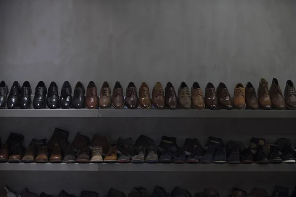 Hyllor med brunt och svart mens skor. Rad mens läderskor. Mens skor, boot säljer i butiken, boutique, köpcentrum. Mens skor koncept. Mens mode, stil, kvalitet, läder, konstläder. — Stockfoto