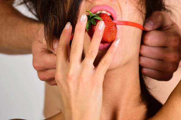 Gag κινηματογράφηση σε πρώτο πλάνο. ο τύπος βάζει η φράουλα στο στόμα της κοπέλας. Ερωτικός σαδομαζοχισμός — Φωτογραφία Αρχείου
