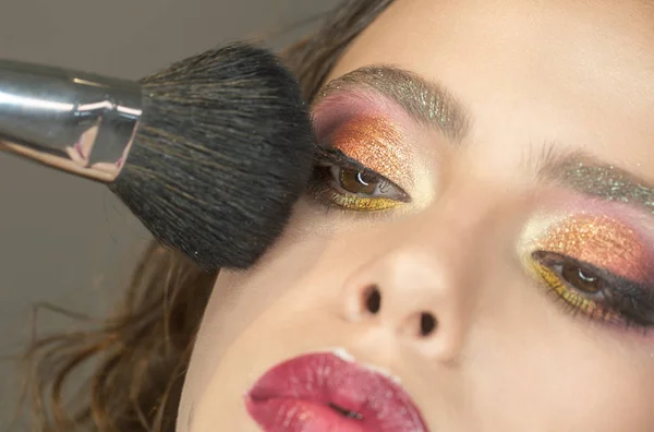 Hermosa mujer aplicando polvo de fundación con cepillo de maquillaje . — Foto de Stock