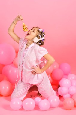 Lolipop şeker pembe renkli bir arka plan önünde ile mutlu sevimli küçük kız
