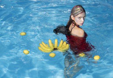 Yaz tatili ve okyanus seyahat. Su kenarında oturan kız muz vitamini. Kadın spa Havuzda rahatlayın. tropikal meyve havuzu olan kadın. Diyet ve sağlıklı organik gıda, vejetaryen.