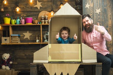 Roket fırlatma kavramı. Elinde çocuk mutlu oturmak roket yaptı. Baba, baba, neşeli kozmonot ile çocuk oyun karton kutudan yapılan roket oturup. Çocuk şirin çocuk oynamak kozmonot, astronot, başparmak.