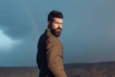 Hipster gökkuşağı gökyüzü önünde şık görünümü ile.