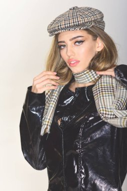 Uzun saç ve makyaj giyer siyah pelerin, ekose kepi, eşarp, açık renkli olan kız. Kadın aksesuarları ile pelerin içinde sakin yüz. Seksi Bayan şık kıyafeti. Moda aksesuarları kavramı.