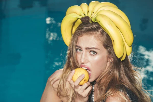 Férias de verão e viagens ao oceano. Mulher sexy com frutas tropicais na piscina. Vitamina em banana em menina perto de água. Dieta e comida orgânica saudável, vegetariana. Mulher relaxar na piscina com limão — Fotografia de Stock