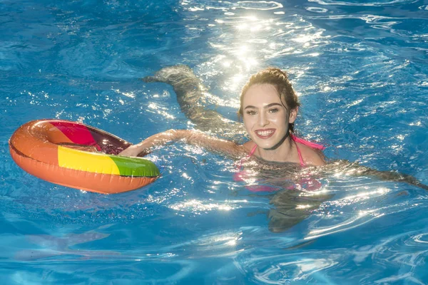 Mulher sexy no mar com anel inflável. mulher feliz nadar com anel colorido inflável na piscina — Fotografia de Stock