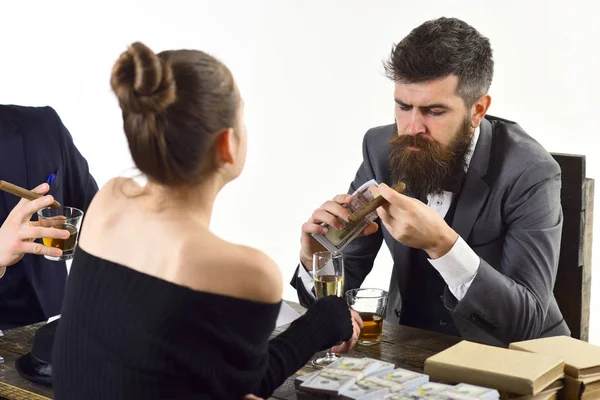 Company engaged in illegal business. Men and woman sitting at table with piles of money. Illegal deal concept. Businessmen discussing illegal deal while drinking and smoking, white background.