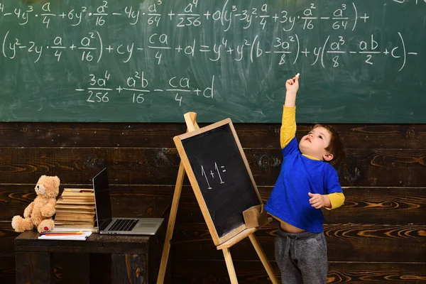 蹑手蹑脚的男孩在教室里指着粉笔 小孩子在学数学 早期发展概念 — 图库照片