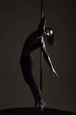 Performans kavramı. Metallis direğe asılı adam.